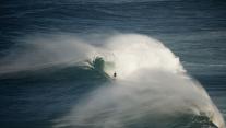 Surfer riding a wave in Nazaré, Portugal 