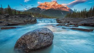 Sunset lights up Mount Fryatt as the Athabasca River flows over Athabasca Falls in Jasper National Park, Alberta, Canada (© Robert Postma/Getty Images)