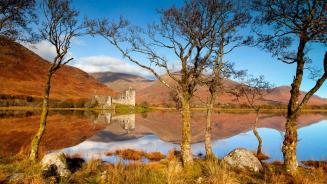 Kilchurn Castle spiegelt sich im Loch Awe, Argyll und Bute, Schottland (© Tom Mackie/plainpicture)