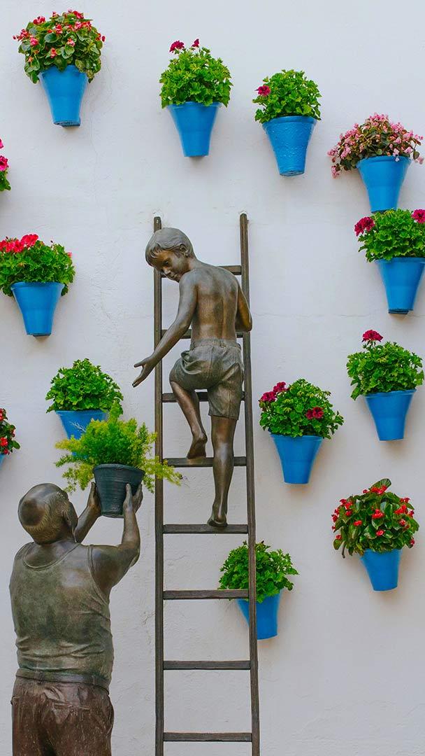 正在照看花草的孩子和祖父铜雕，西班牙科尔多瓦 (© David M G/Alamy)